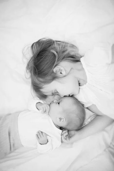 Μικρή μεγάλη αδελφή ξαπλωμένη δίπλα σε ένα νεογέννητο μωρό. — Φωτογραφία Αρχείου