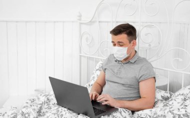 Yatak odasında maske takan serbest çalışan biri..