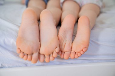 Yataktaki küçük bacaklar. pembe ayaklar ve düz topuklar