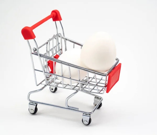 Uovo di pollo nel carrello della spesa giocattolo. isolato bianco . — Foto Stock