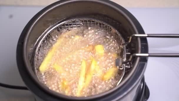Olie kokend in een frituurpan thuis. Franse frietjes. — Stockvideo