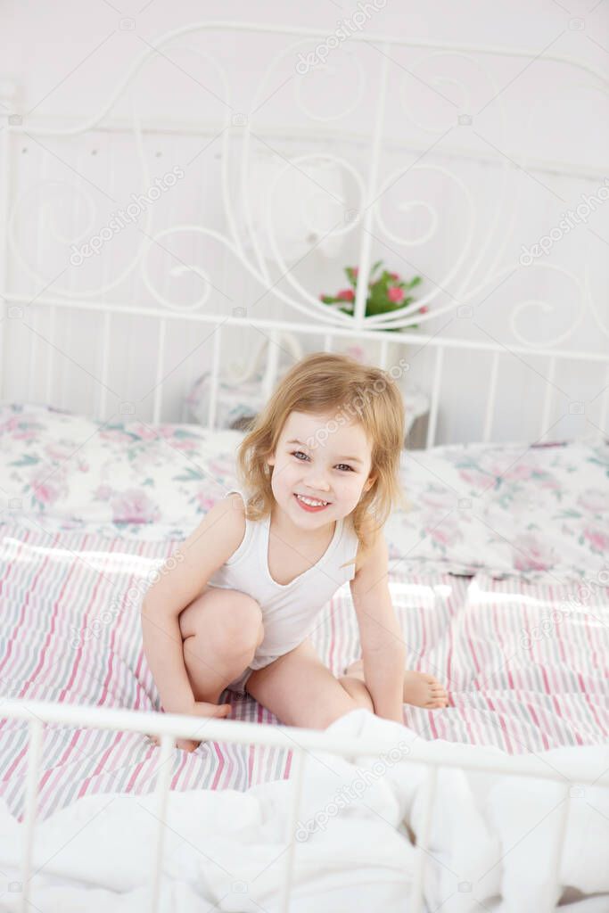 little girl sitting on bed in parents bedroom.