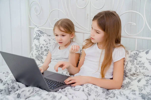 Quédate en casa. dos hermanas estudio en la computadora en línea . — Foto de Stock