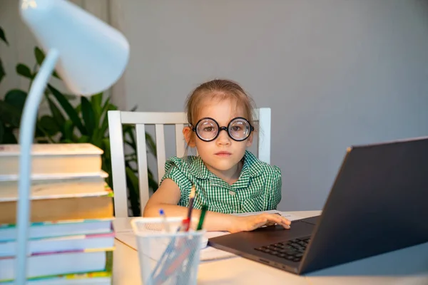 Niña en gafas grandes aprendizaje en el ordenador portátil . — Foto de Stock