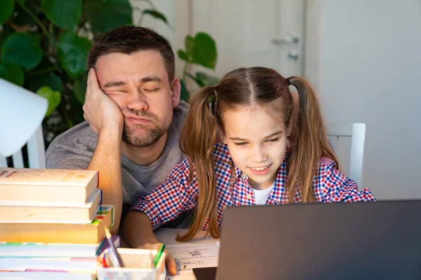 Soñoliento papá ayuda hija lecciones en línea en el ordenador portátil — Foto de Stock