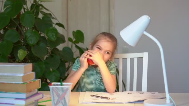 Niña comiendo una manzana durante las clases de descanso — Vídeos de Stock