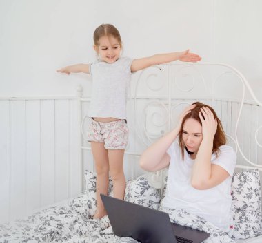 little girl interferes to work mom at home. clipart