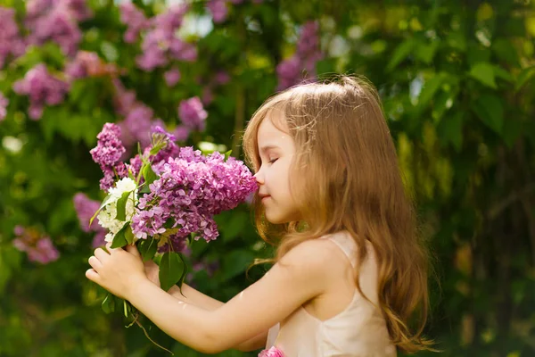 Menina perto de flores lilás buquê de rapé — Fotografia de Stock
