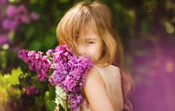 Menina bonita em perto de flores lilás com buquê — Fotografia de Stock