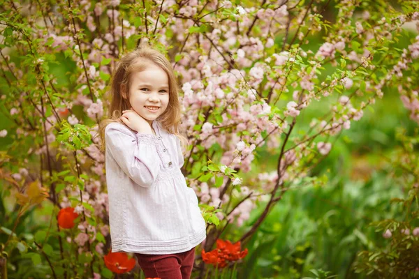 Menina perto com amêndoa arbusto e tulipas — Fotografia de Stock