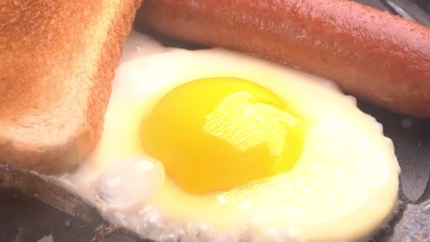 Замедление. жареные яйца с колбасой на горячей сковороде . — стоковое видео