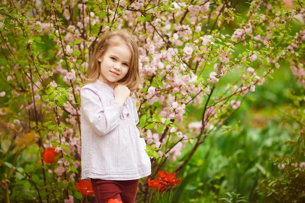 Niña pequeña cerca con arbusto de almendra y tulipanes —  Fotos de Stock