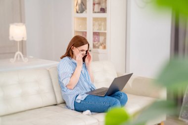 Kanepede bilgisayar okuyan serbest çalışan bir kadın.. 