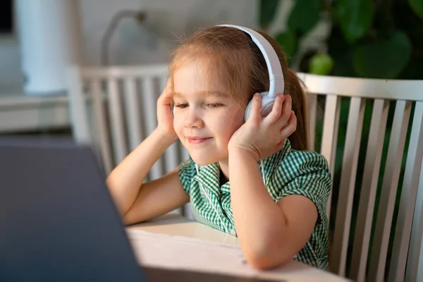 Fille dans casque écoute leçon en ligne sur ordinateur portable — Photo