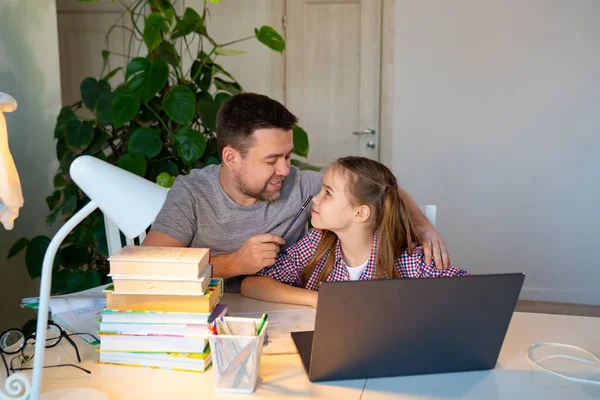 Papá ayuda a su hija con lecciones en línea en el ordenador portátil — Foto de Stock