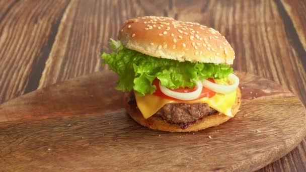 Niño manos tomar hamburguesa con una tabla de madera . — Vídeo de stock