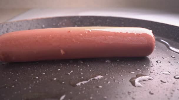 A linguiça cai em uma panela de ato de fritar quente. câmara lenta . — Vídeo de Stock