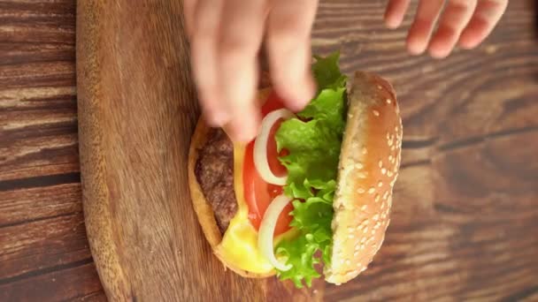 Kid hands take burger with board. vertical videos. — Stock Video