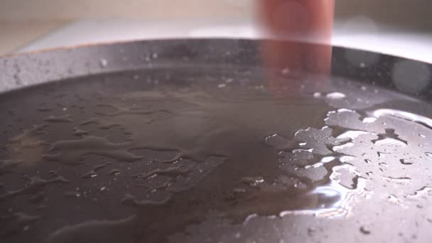 Een worst valt op een hete koekenpan. slow motion — Stockvideo