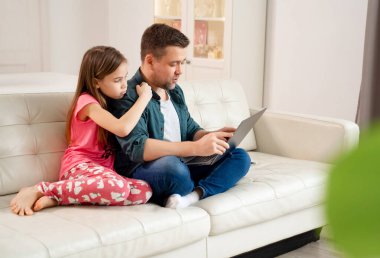 Serbest çalışan kız ve kız kanepede dizüstü bilgisayarda çalışıyorlar..