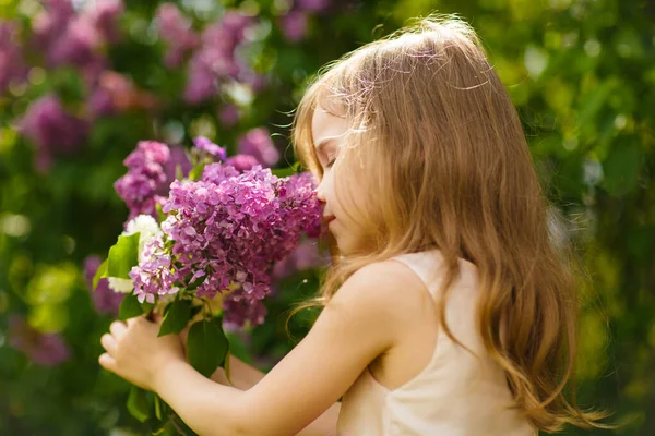 Niña cerca de flores lila snuff bouquet — Foto de Stock