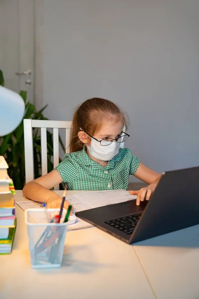 Gözlüklü ve maske takan çocuk bilgisayardan uzak duruyor. — Stok fotoğraf