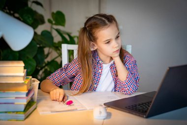 Liseli kız internetten bilgisayar dersi dinliyor. 