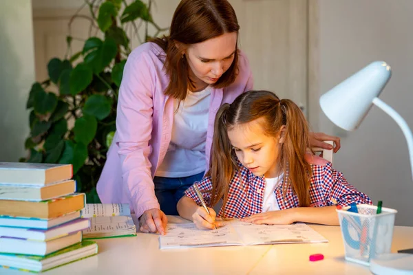 Mamá ayudar a su hija haciendo lecciones, aprendizaje a distancia — Foto de Stock