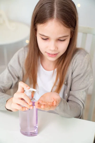 Menina adolescente usa desinfetante para limpar as mãos . — Fotografia de Stock