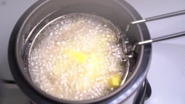 Evdeki fritözde kaynamış yağ. Patates kızartması.