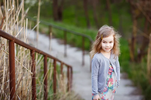 Dítě dívka stojící na schodech s vysokým madlem. — Stock fotografie