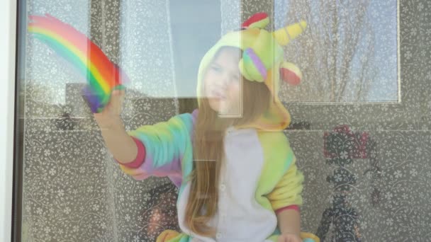 Bambina disegna l'arcobaleno sulla finestra . — Video Stock