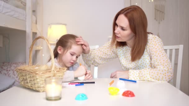Anya és lánya díszíteni élelmiszer markerek és stencil húsvéti tojás. — Stock videók