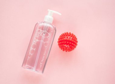 Pembe üzerine bir şişe antiseptik ve model COVID 19..