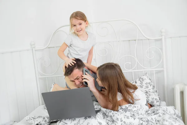 Niños interferir papá freelancer en cuarentena en la cama — Foto de Stock