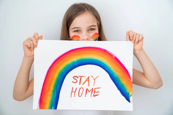 blond teen girl drew rainbow and poster stay home.