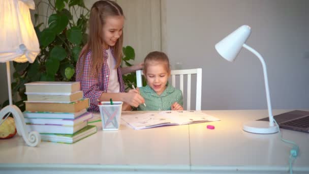 Oudere zus helpt de jongere kinderen met hun lessen, — Stockvideo