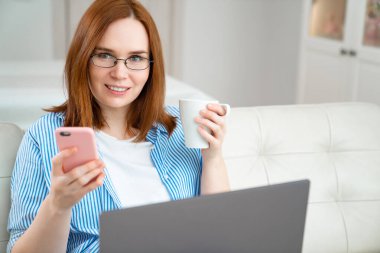 Kadın çay içer ve mesajları okur..