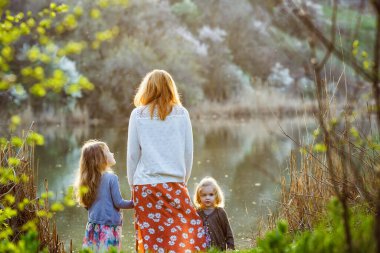 Annesi ve kızı bankalarda duruyor. arka plan. 