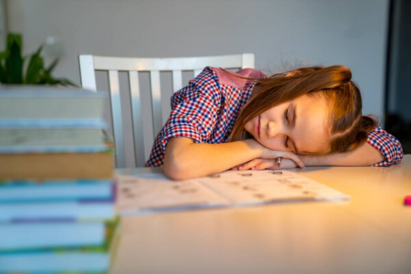 сонная школьница делает домашнее задание. обучение на дому
