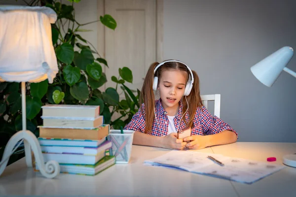 Colegiala en auriculares escuchando música — Foto de Stock