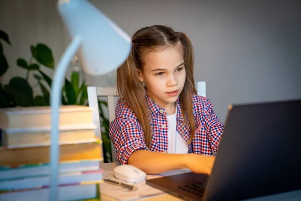 Chica hace las lecciones, la tarea en el portátil . — Foto de Stock