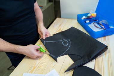 Erkek elleri makasla desen maskesini keser.