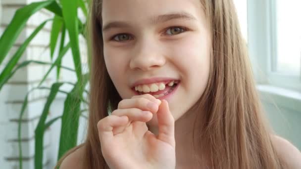 Симпатичная девочка-подросток с молочным зубом выпала. — стоковое видео