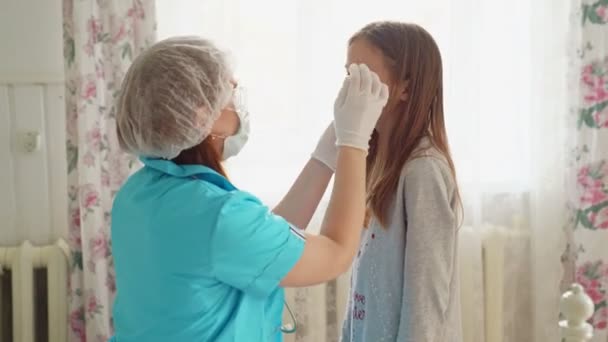 Médico en máscara examina niño en casa y abrazos . — Vídeo de stock