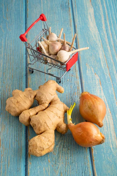 Gengibre, cebola, alho no carrinho de compras mini — Fotografia de Stock