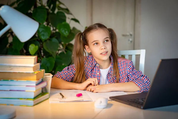 Adolescente chica escucha lección en un portátil y escribe — Foto de Stock