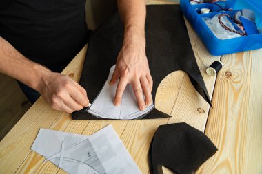 Erkek elleri makasla desen maskesini keser.