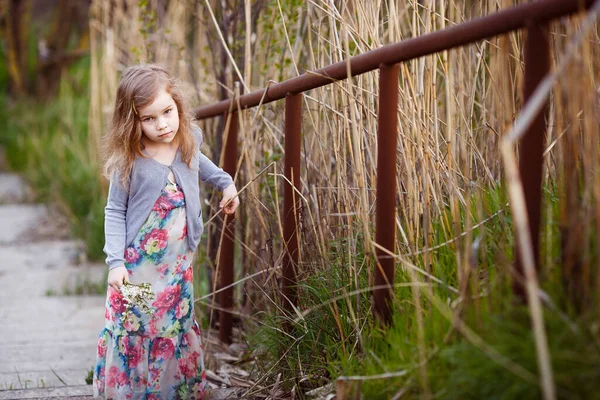 Niña pequeña de pie en las escaleras con barandilla alta . —  Fotos de Stock