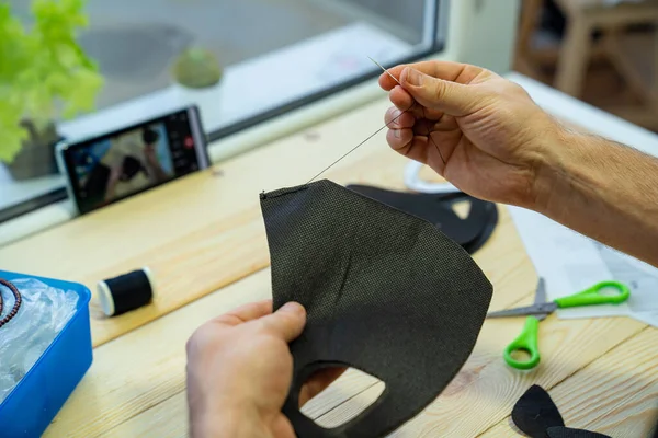 Manos de hombre coser con una máscara de aguja negro —  Fotos de Stock